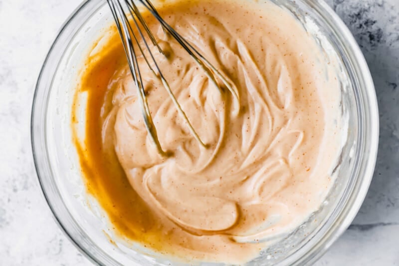 yum yum sauce in a glass bowl with a whisk.