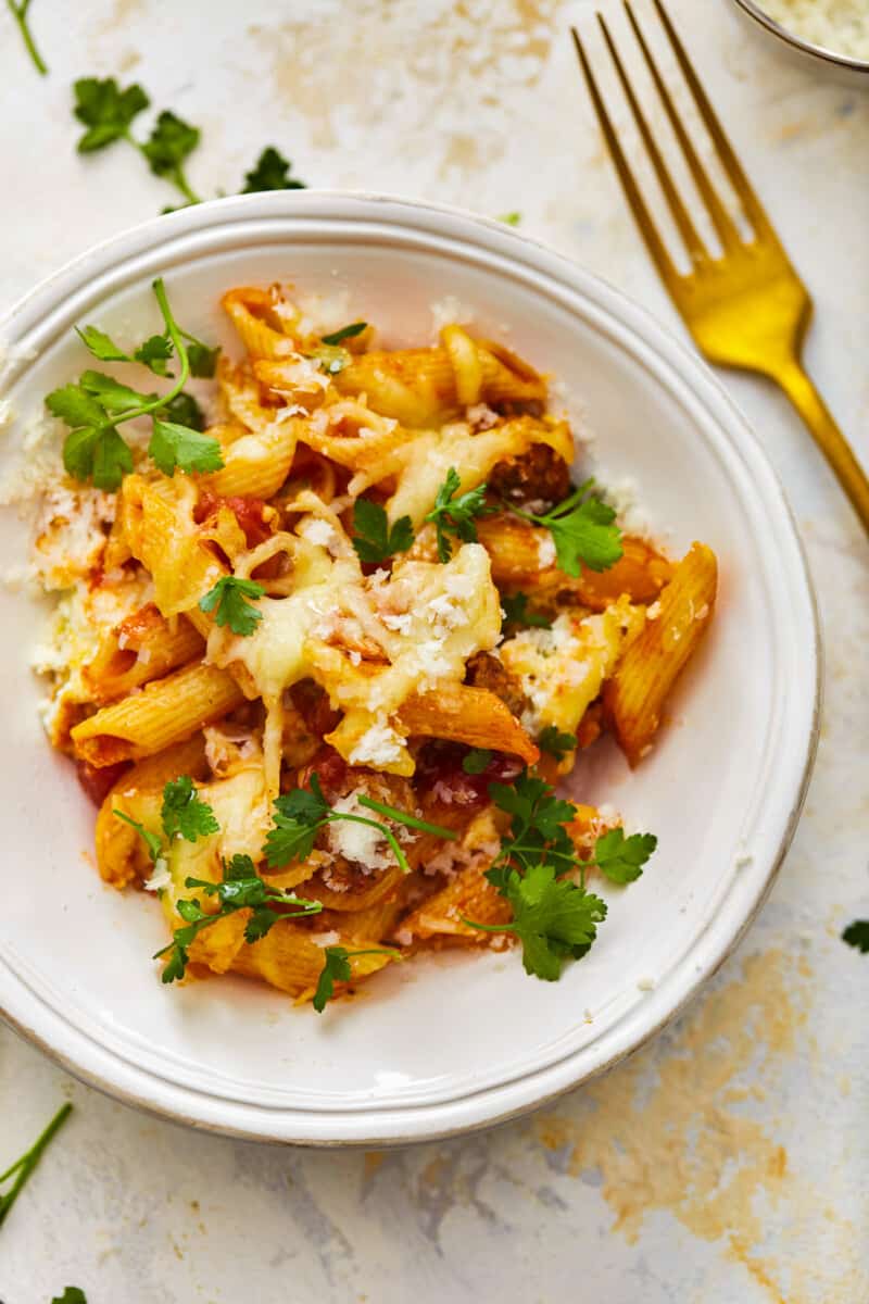 a plate of mostaccioli next to a fork