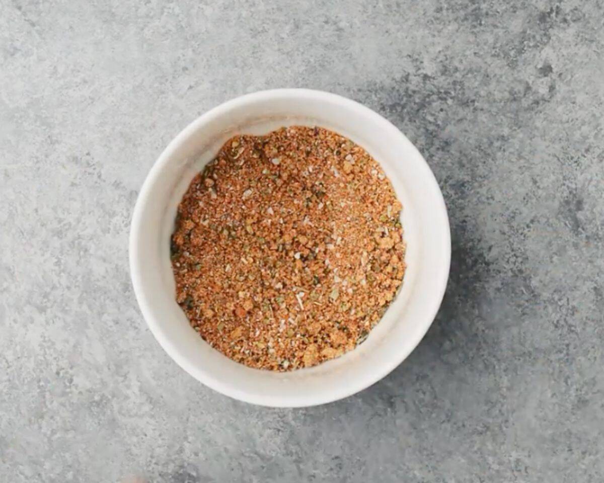 Bowl of homemade chicken seasoning made with brown sugar, paprika, Italian seasoning, and spices on a gray surface - 9