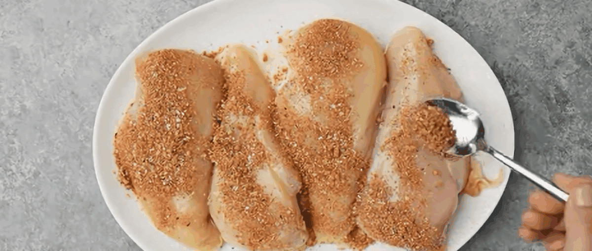Coating the chicken breasts with seasoning.