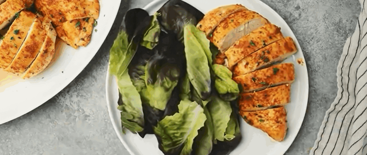 Chicken breasts on a plate with lettuce.