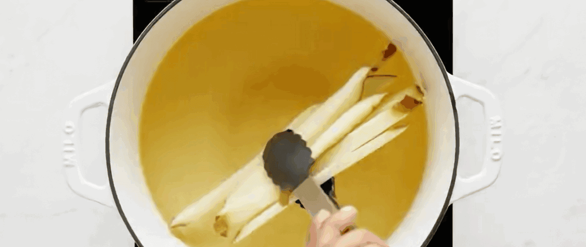 Placing the fries in a pot of oil.