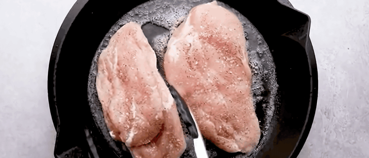 Searing chicken breasts in a black skillet. - 7