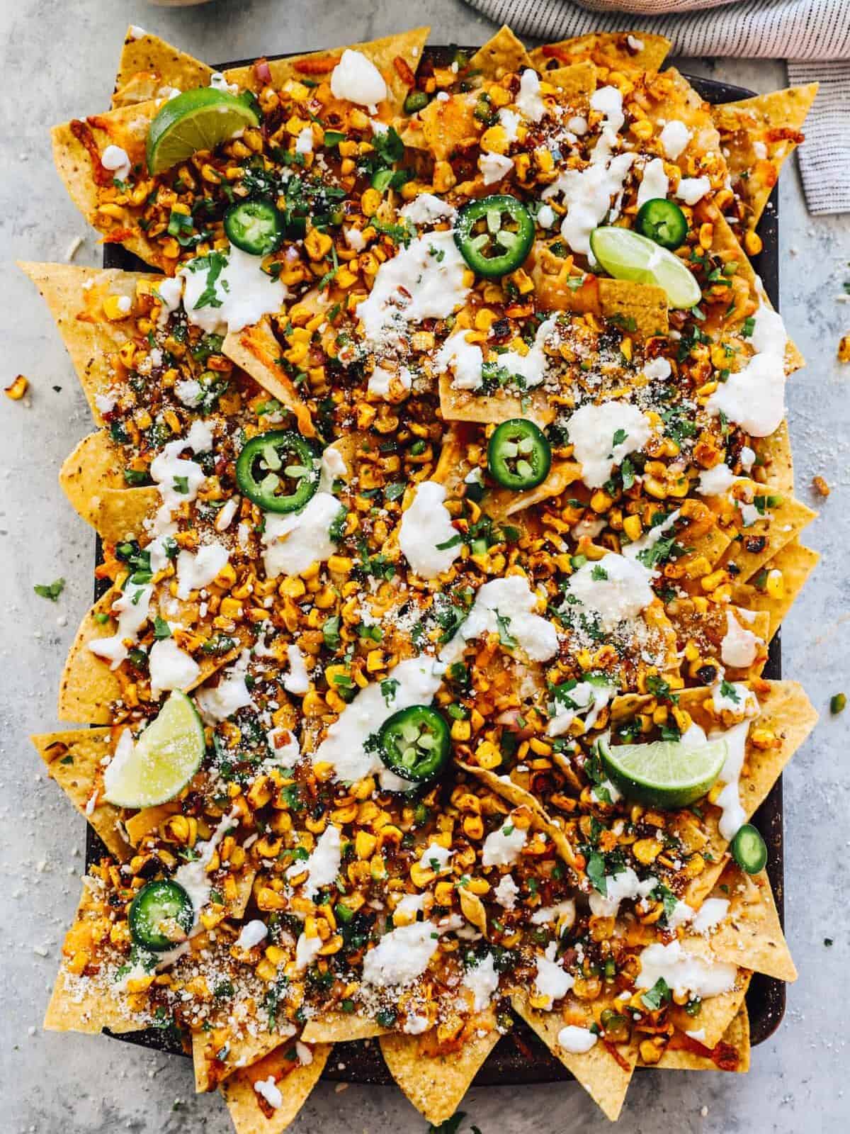 overhead view of street corn nachos on a baking sheet.