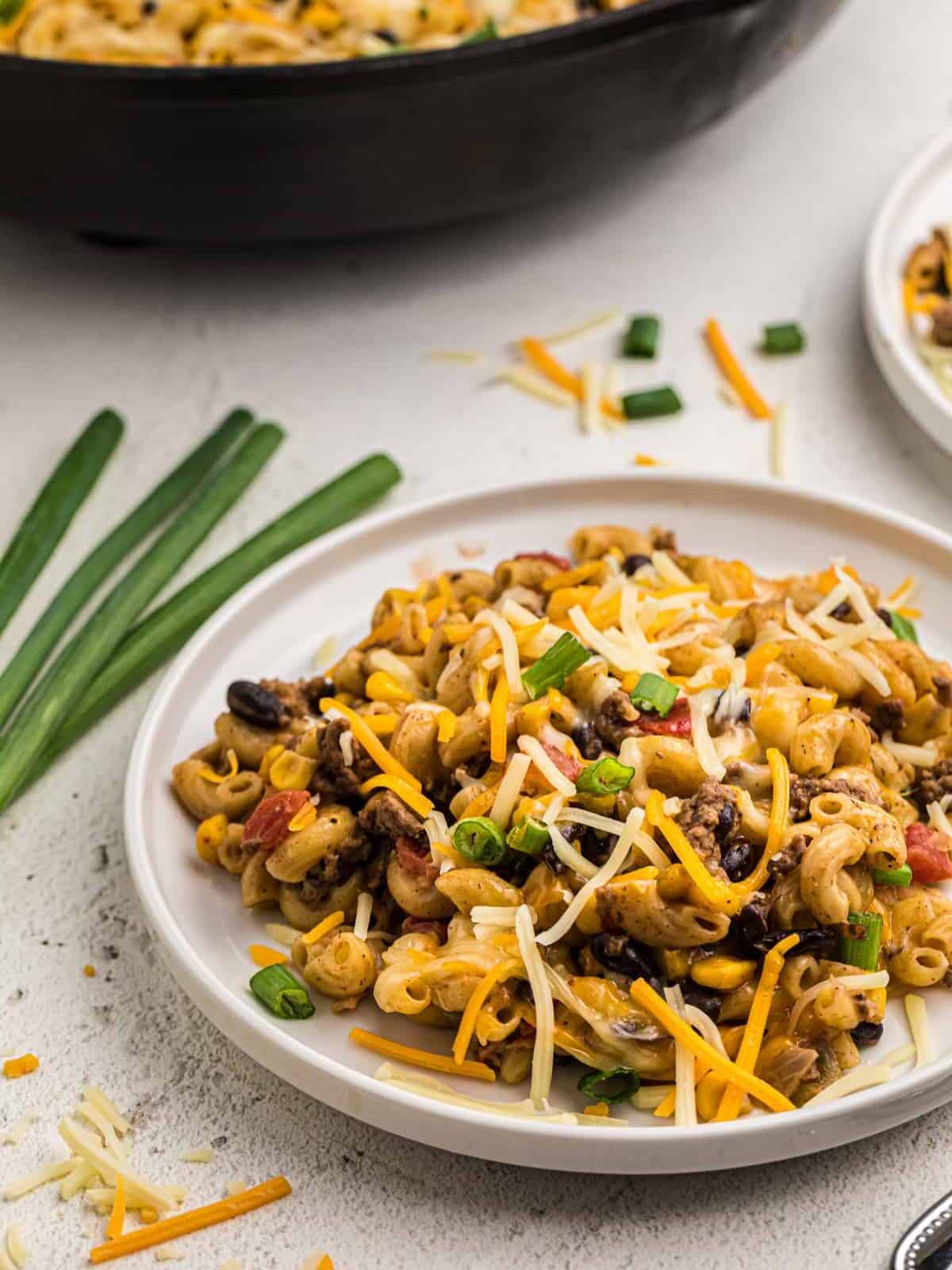 three-quarters view of a serving of taco mac and cheese on a white plate.