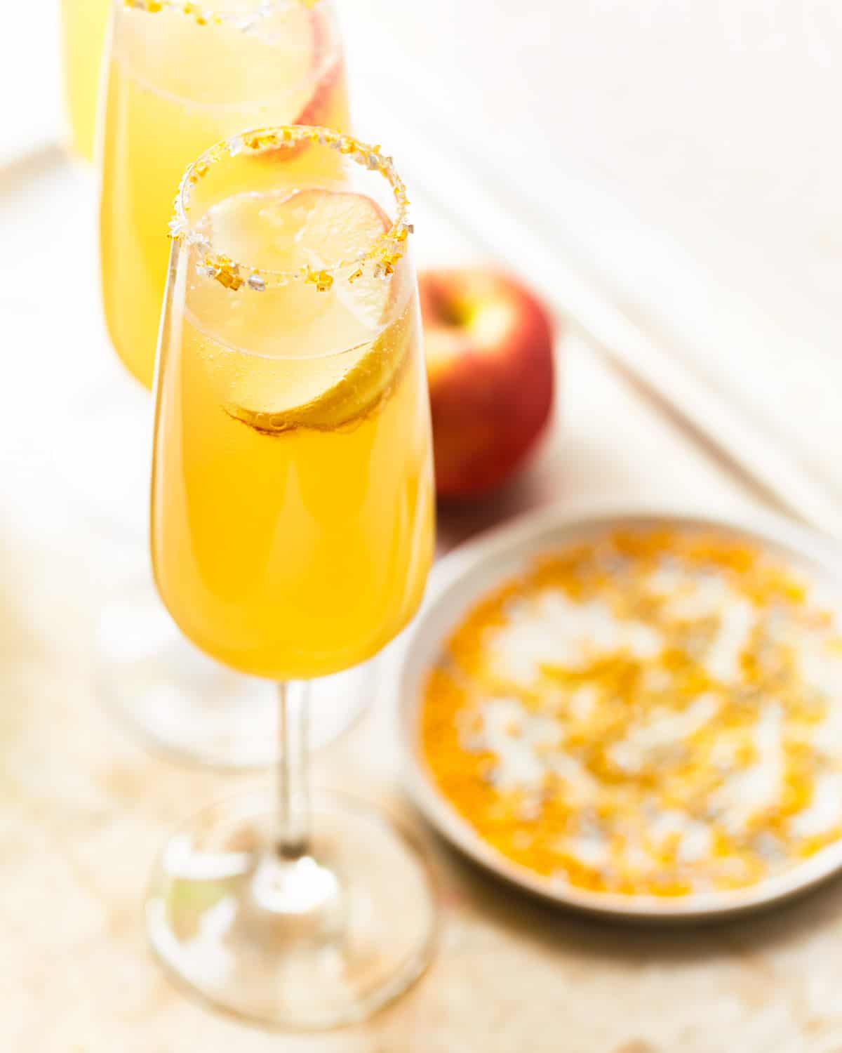 two apple cider mimosas in champagne flutes 
