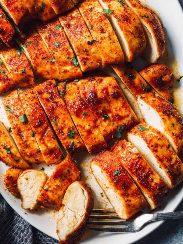 baked chicken breasts sliced on white platter