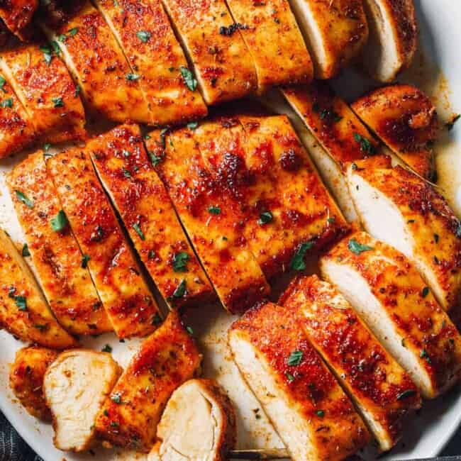 baked chicken breasts sliced on white platter
