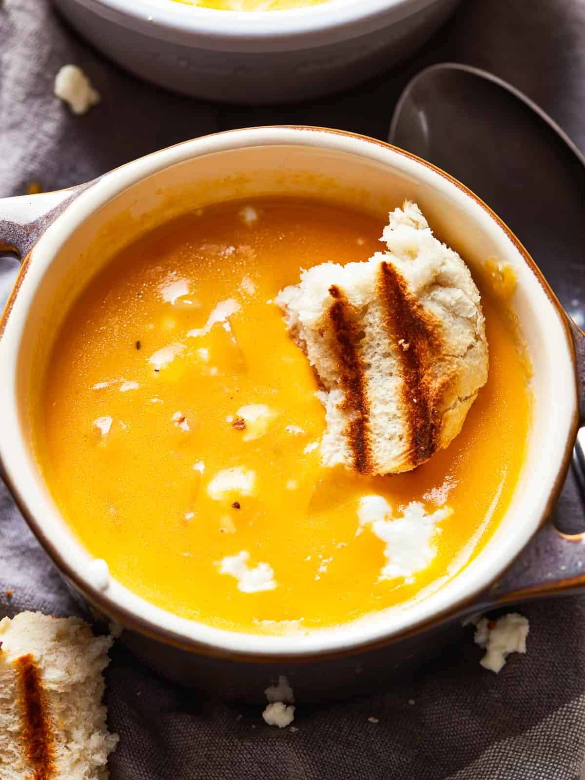 This Beer Cheese Soup recipe is so delicious and made in just 15 minutes! This creamy comfort food is the perfect winter dinner recipe. If you love cheese and beer (what could be better?), this easy beer cheese soup is just for you. a bowl of creamy beer cheese soup