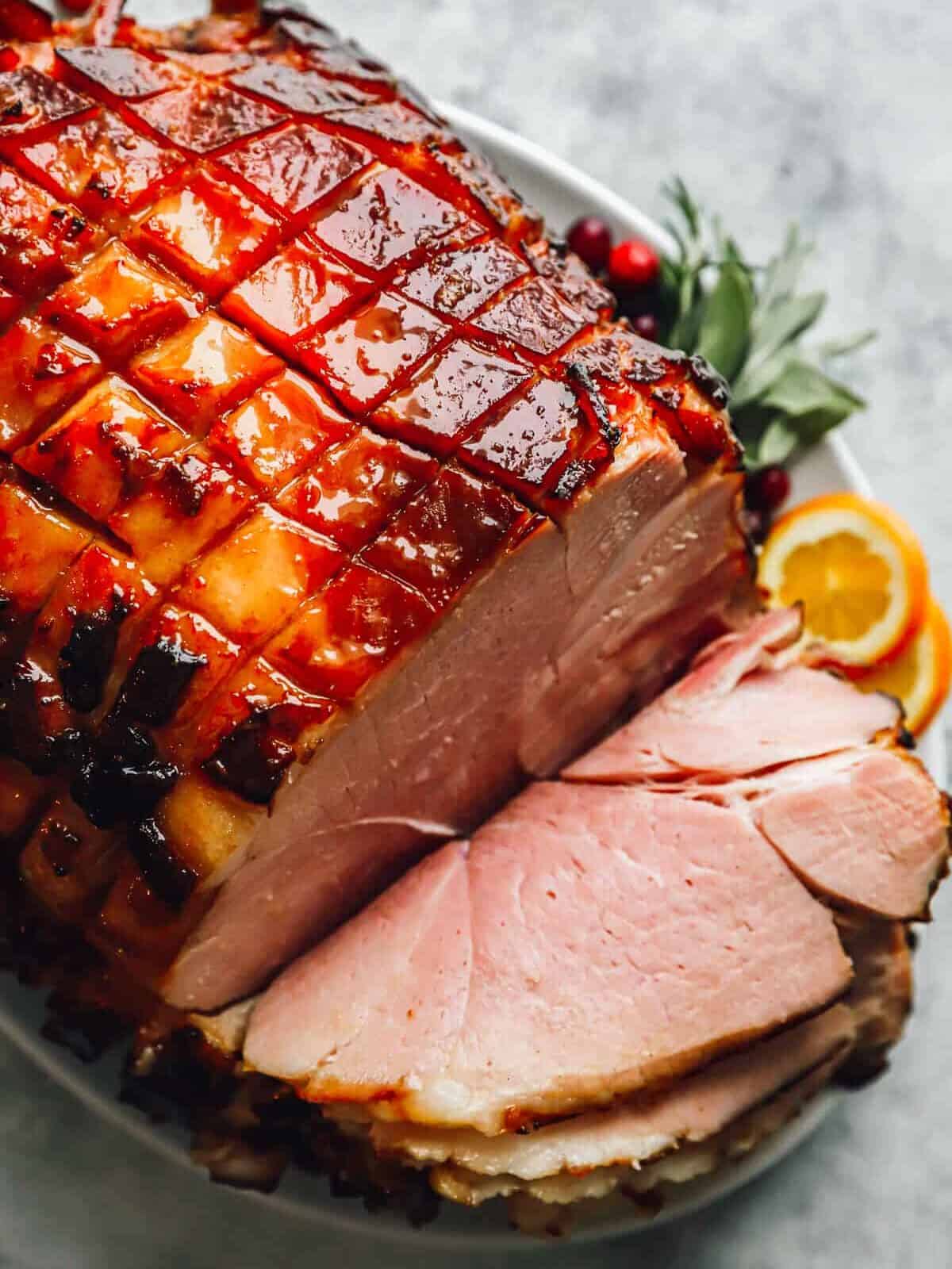 sliced brown sugar glazed ham on a platter.