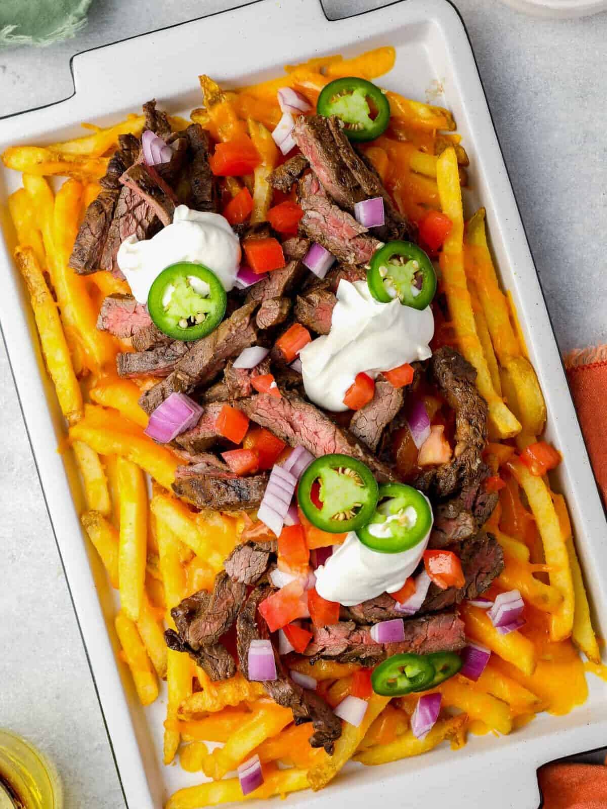 overhead view of carne asada fries on a white tray.