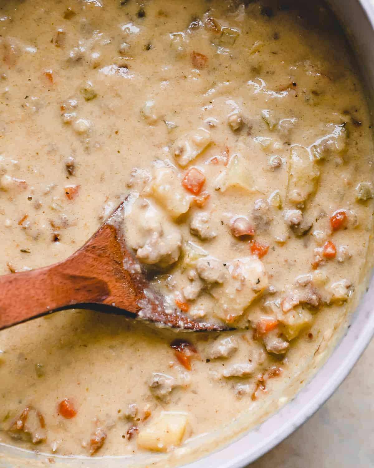 partial overhead view of cheeseburger soup with velvet cheese and ground beef