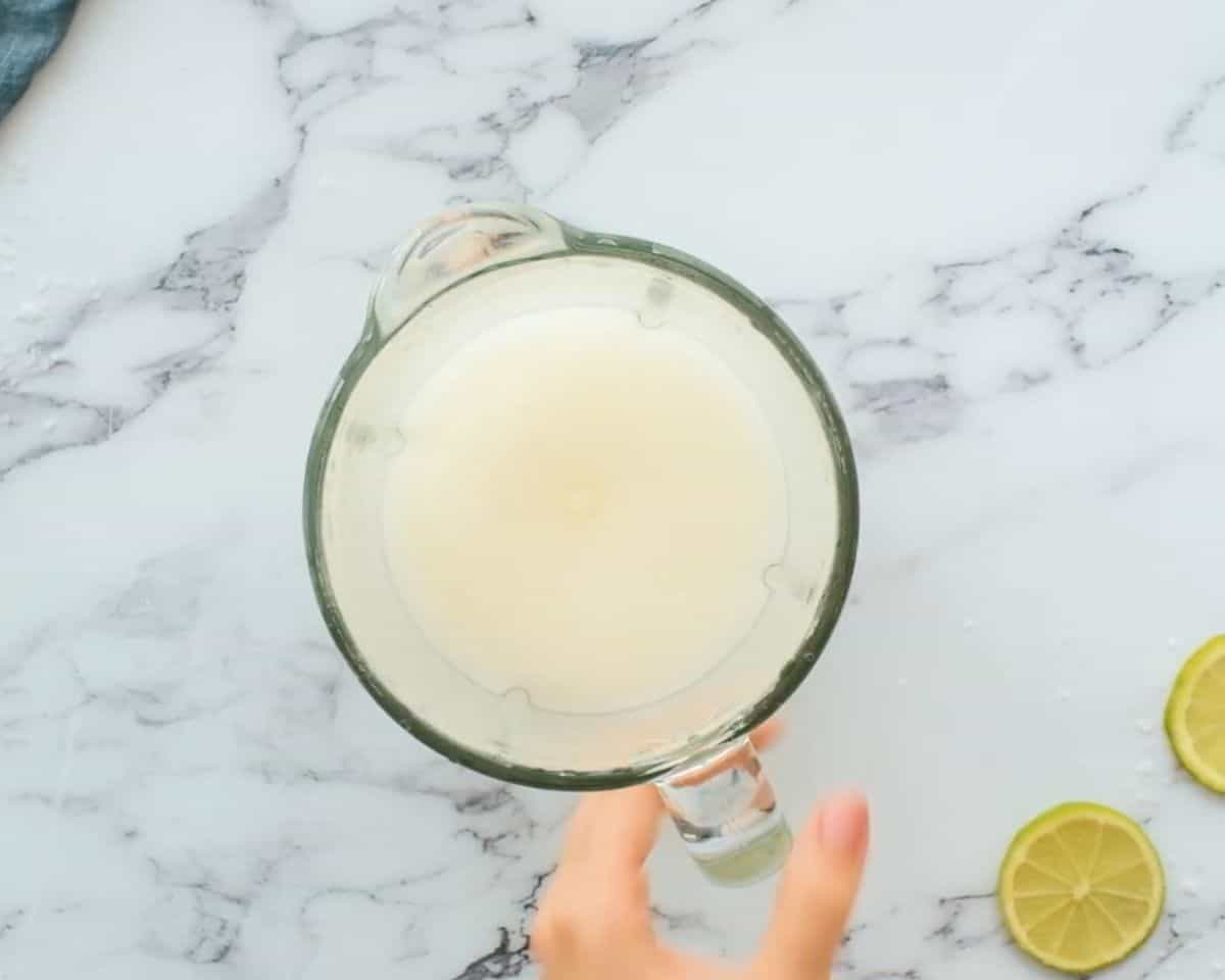 Blended frozen margarita mixture in a blender pitcher with a smooth, thick, slushy texture ready to serve.