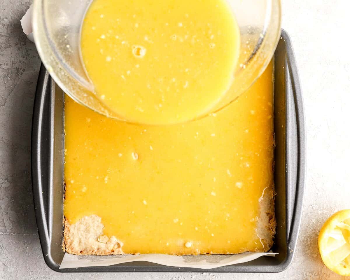 Pouring lemon filling over baked gluten-free shortbread crust