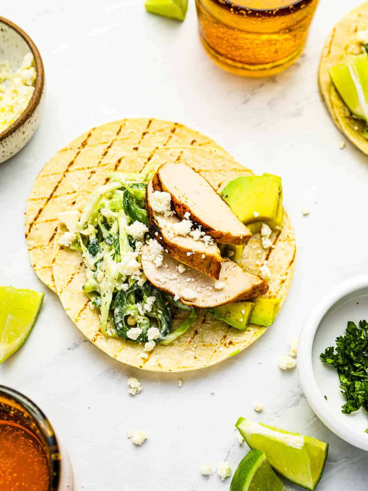 overhead view of an open-faced grilled chicken taco on top of another grilled tortilla.