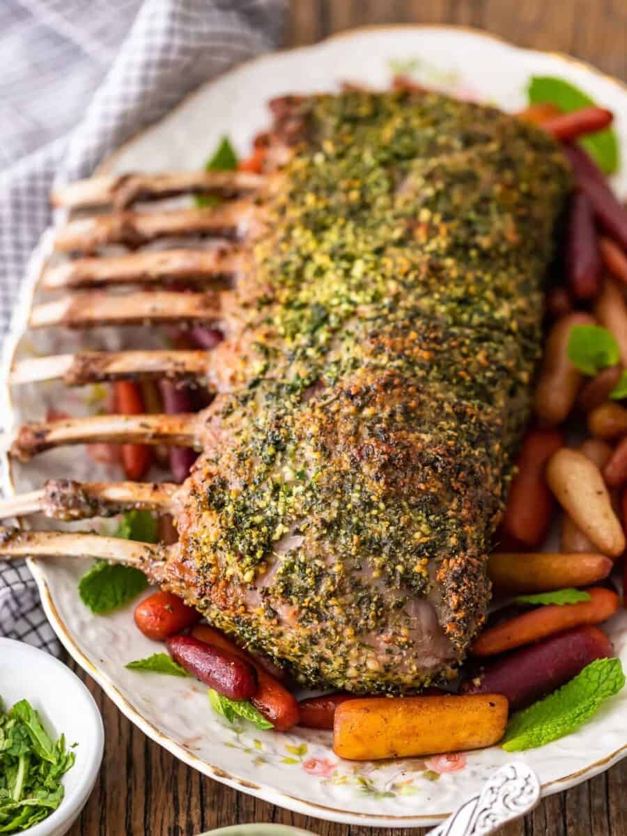 roasted lamb with carrots and herbs on a plate.
