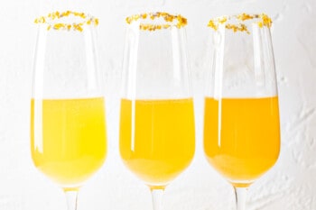 three champagne flutes filled halfway with apple cider