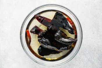 black pepper in a glass bowl on a white background.