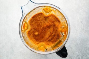 a blender filled with orange sauce.