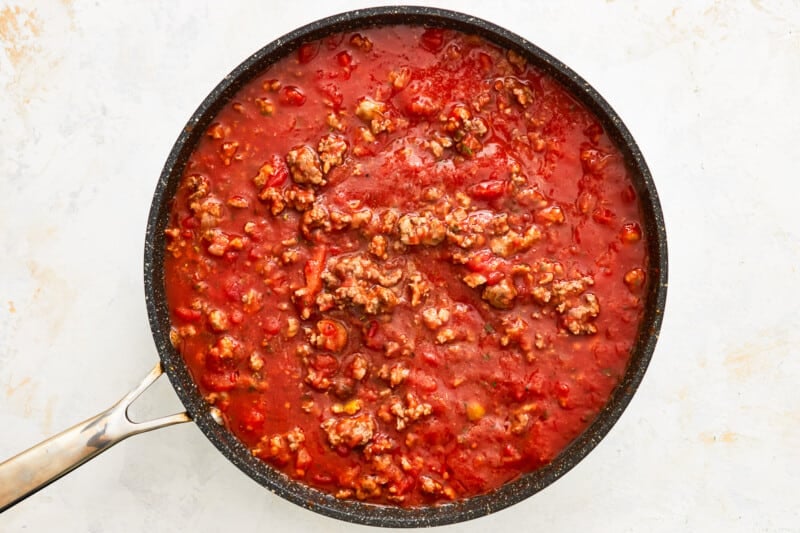 a skillet full of tomato sauce with meat in it.
