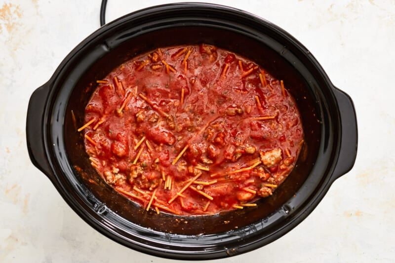a crock pot full of spaghetti and meatballs.