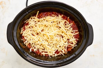a crock pot filled with cheese and meat.
