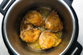 chicken in an instant pot on a stovetop.