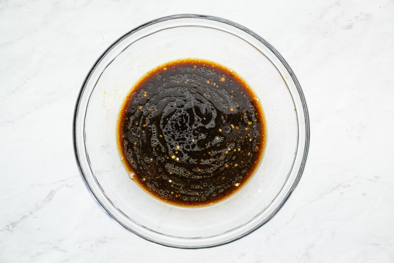 a bowl filled with sauce on a marble countertop.