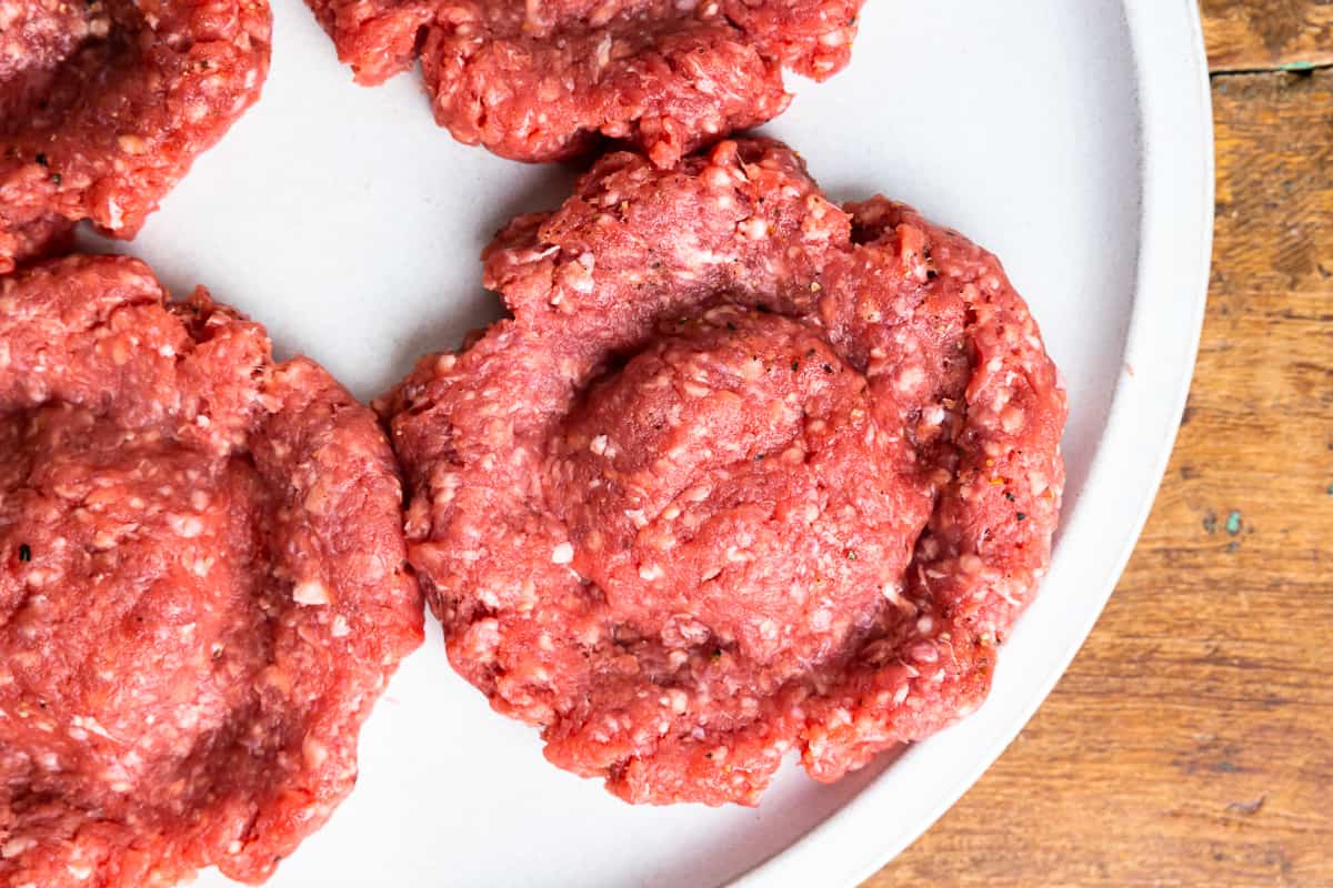 raw burger patty with a "moat" pressed into it - how to cook burgers on the stove
