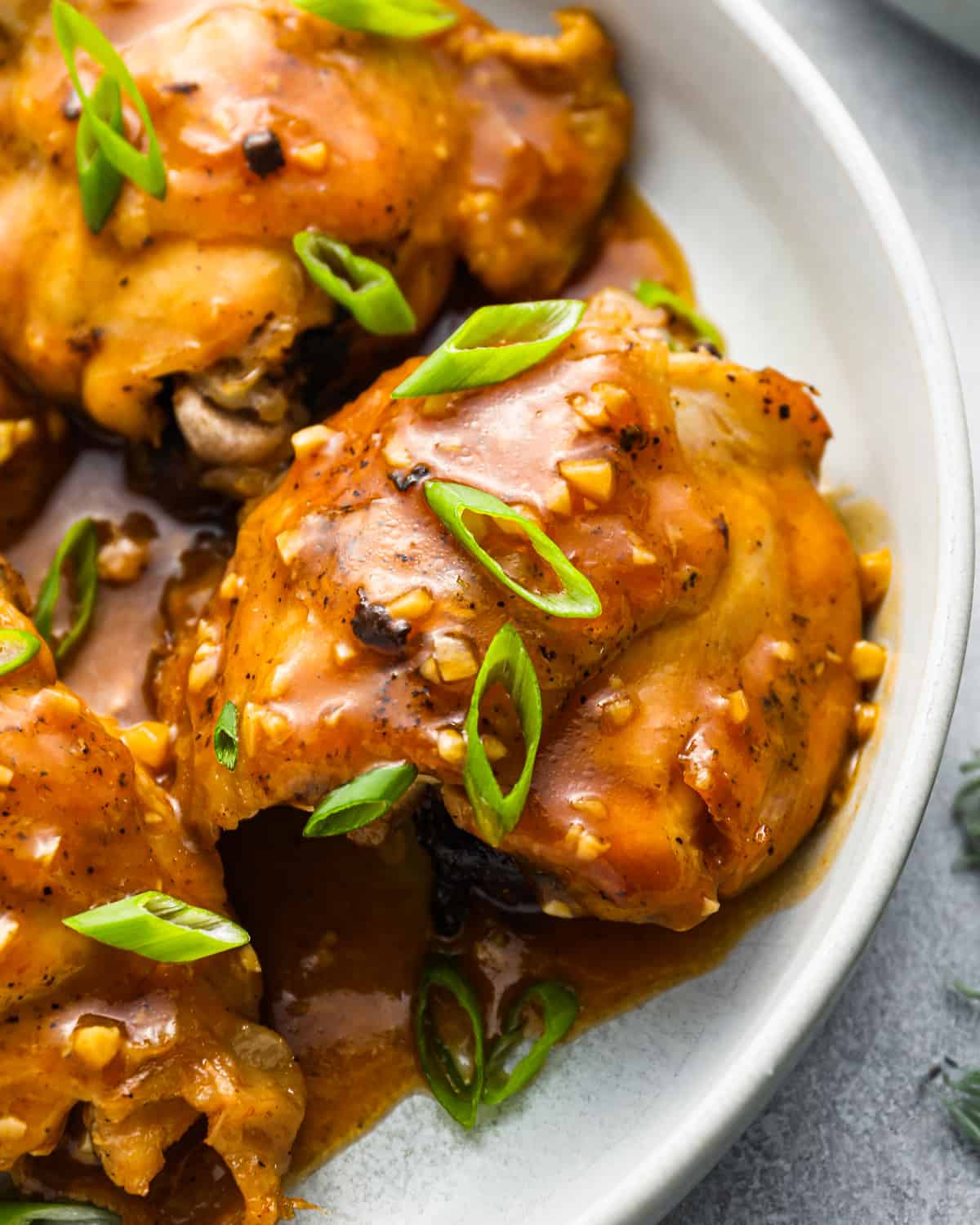 instant pot chicken thighs with sauce on a white plate.