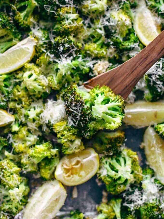 wooden spoon on a baking sheet of broccoli