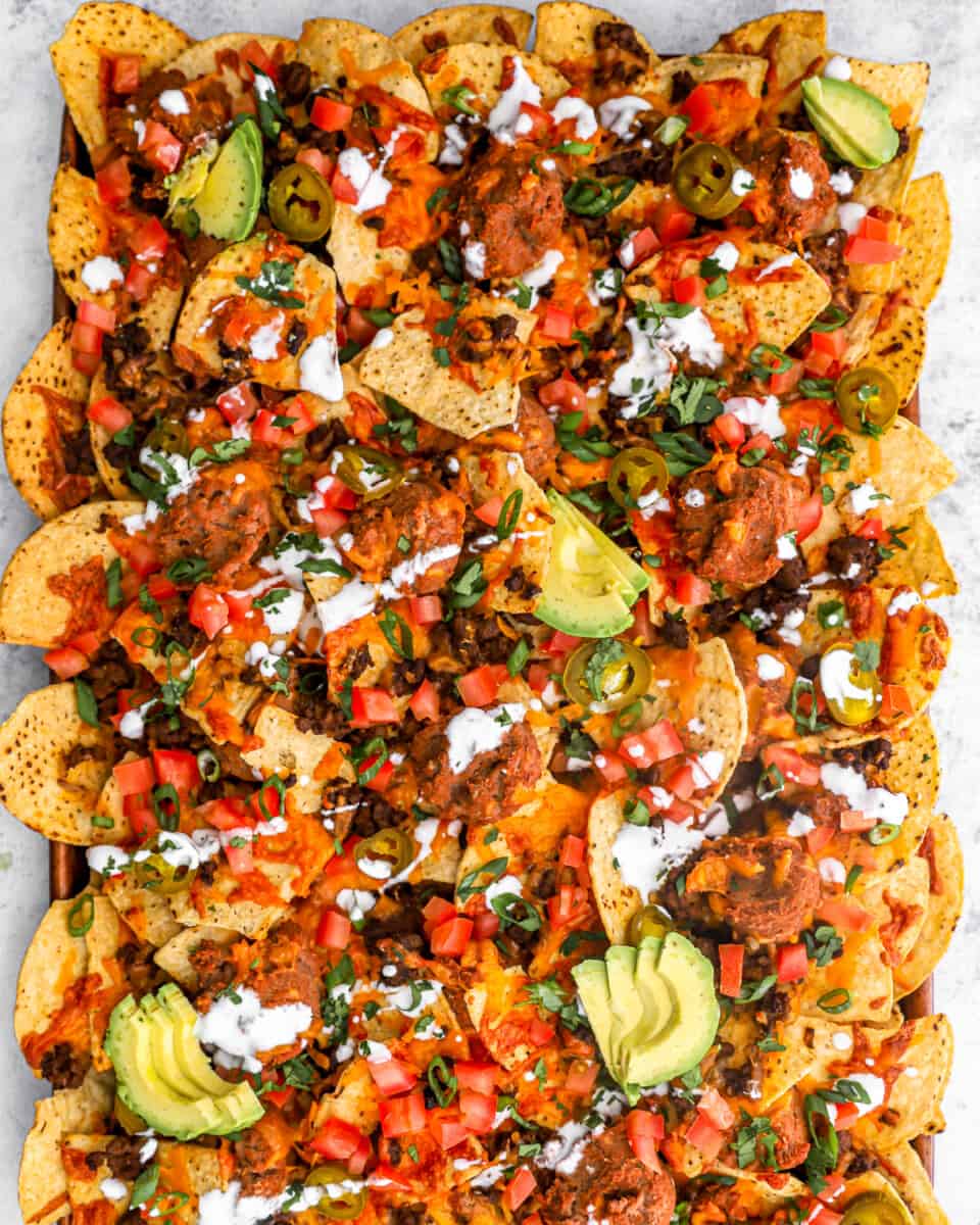 overhead view of nachos supreme on a rimmed baking sheet.