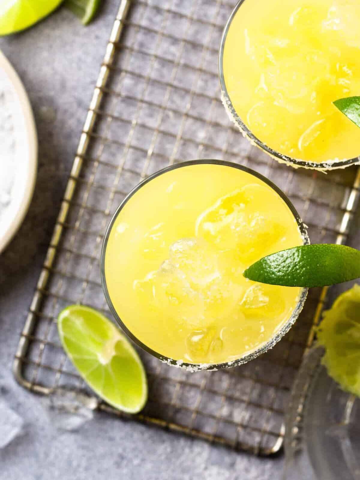 overhead view of a skinny margarita in a rocks glass with a lime wedge.