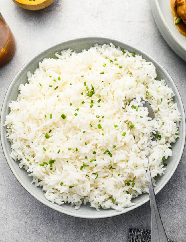 overhead view of stovetop basmati rice in a white bowl with a spoon.