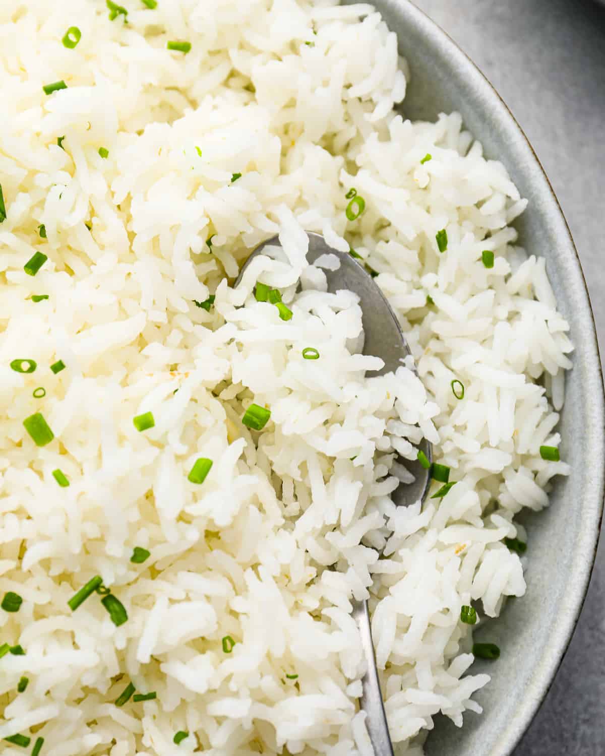close up overhead view of stovetop basmati rice in a white bowl with a spoon.