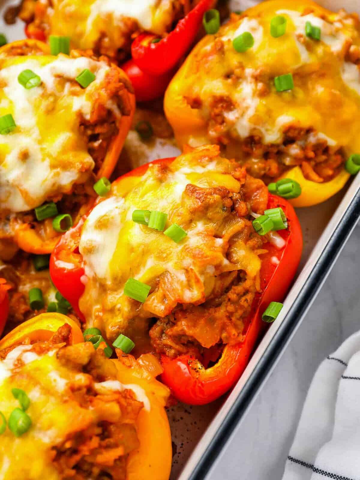 close up of stuffed peppers in a white rectangular baking pan.