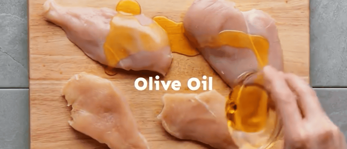 Coating the chicken breasts with olive oil
