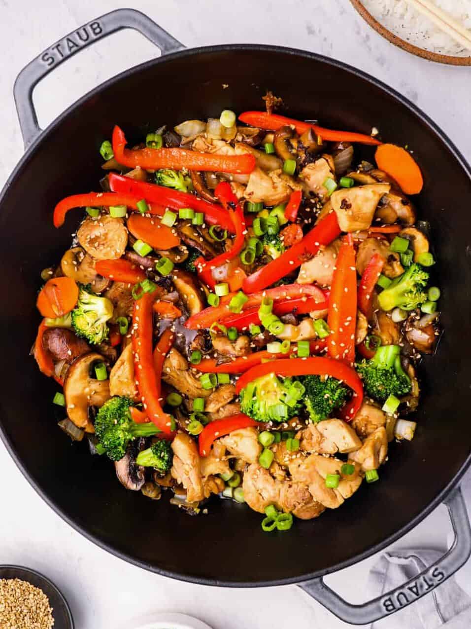 overhead view of chicken stir fry in a cast iron wok.