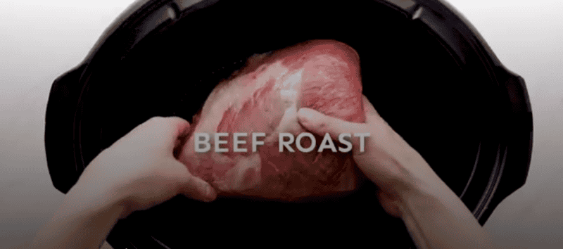 beef roast being placed in the crockpot
