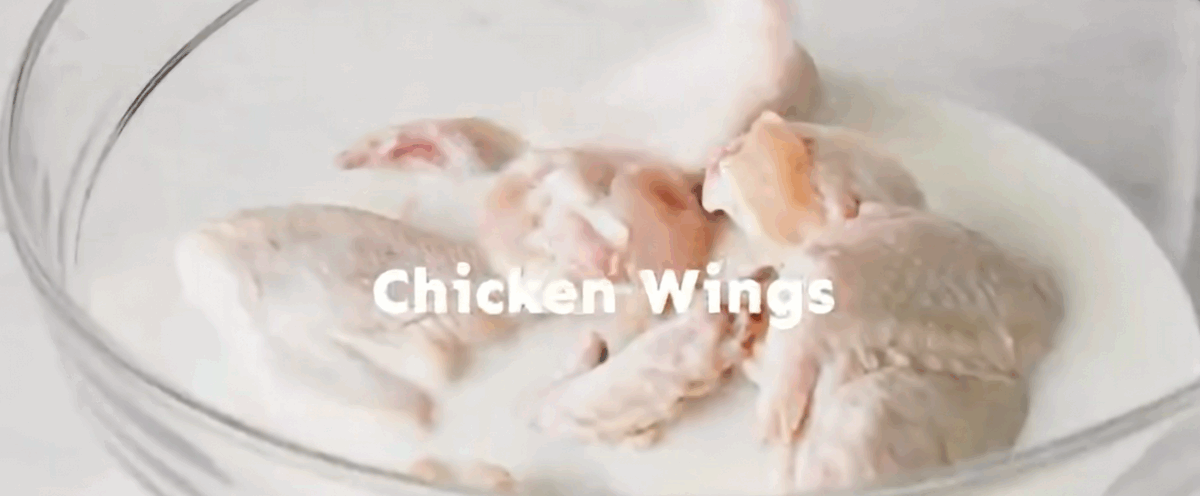 Chicken wings in a bowl with buttermilk.