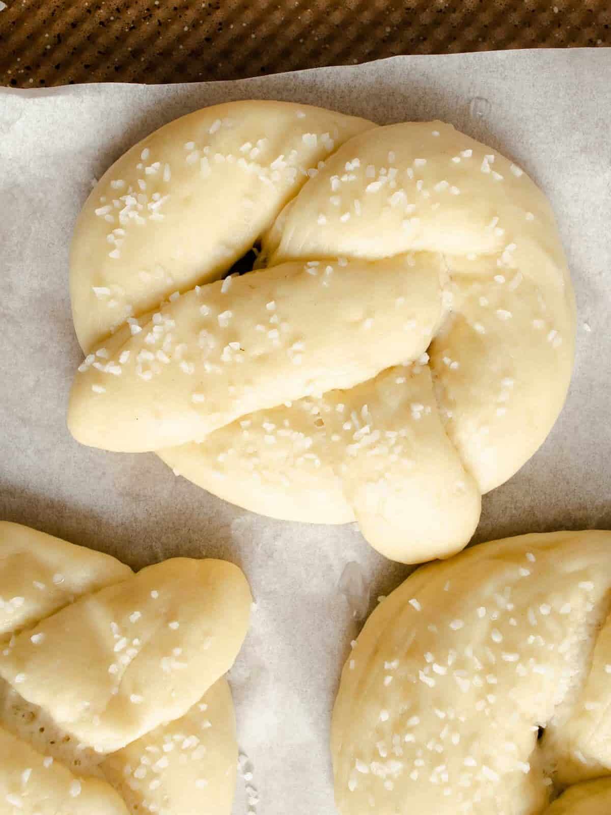 close up of proofed homemade pretzels with salt.