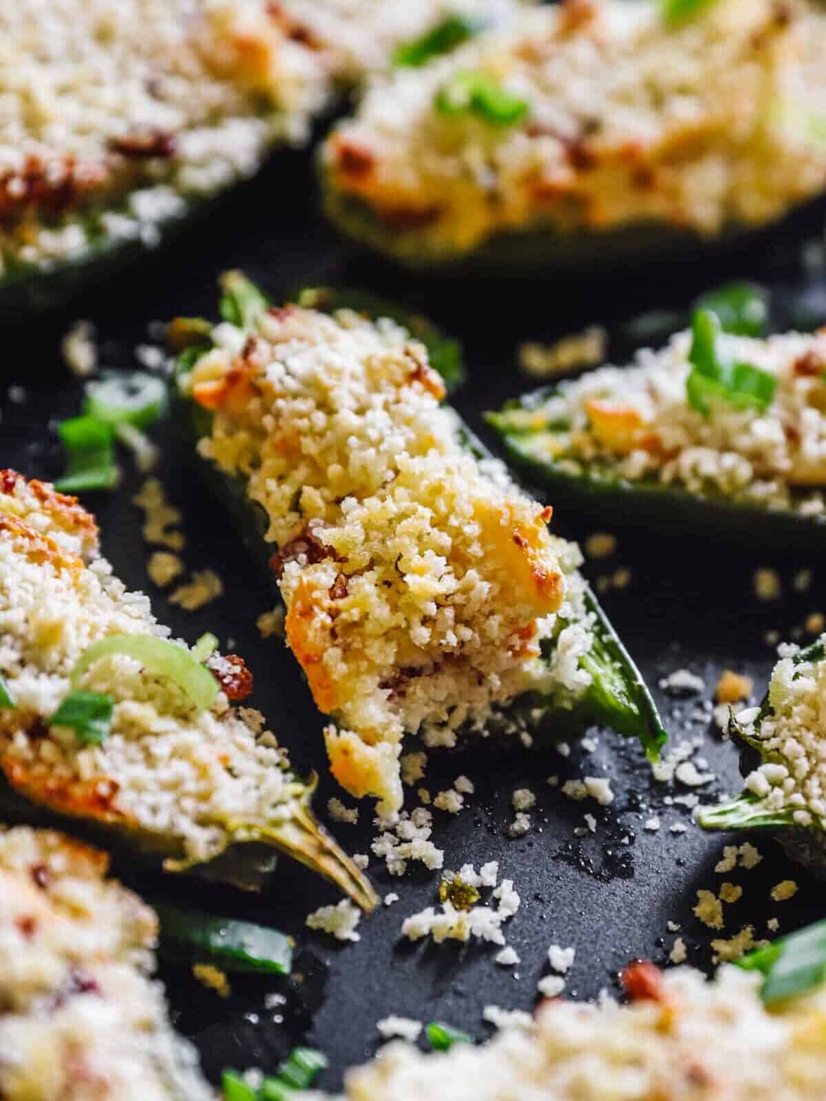close up on jalapeño poppers, one with a bite taken out