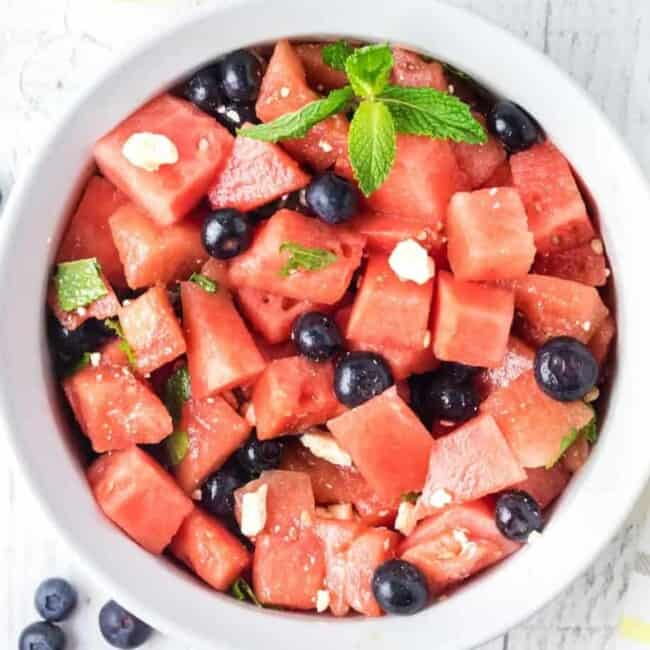 overhead view of watermelon salad in a white serving bowl.