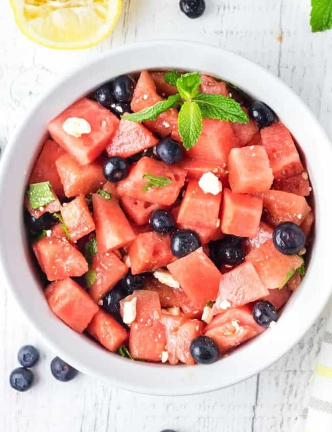 overhead view of watermelon salad in a white serving bowl.