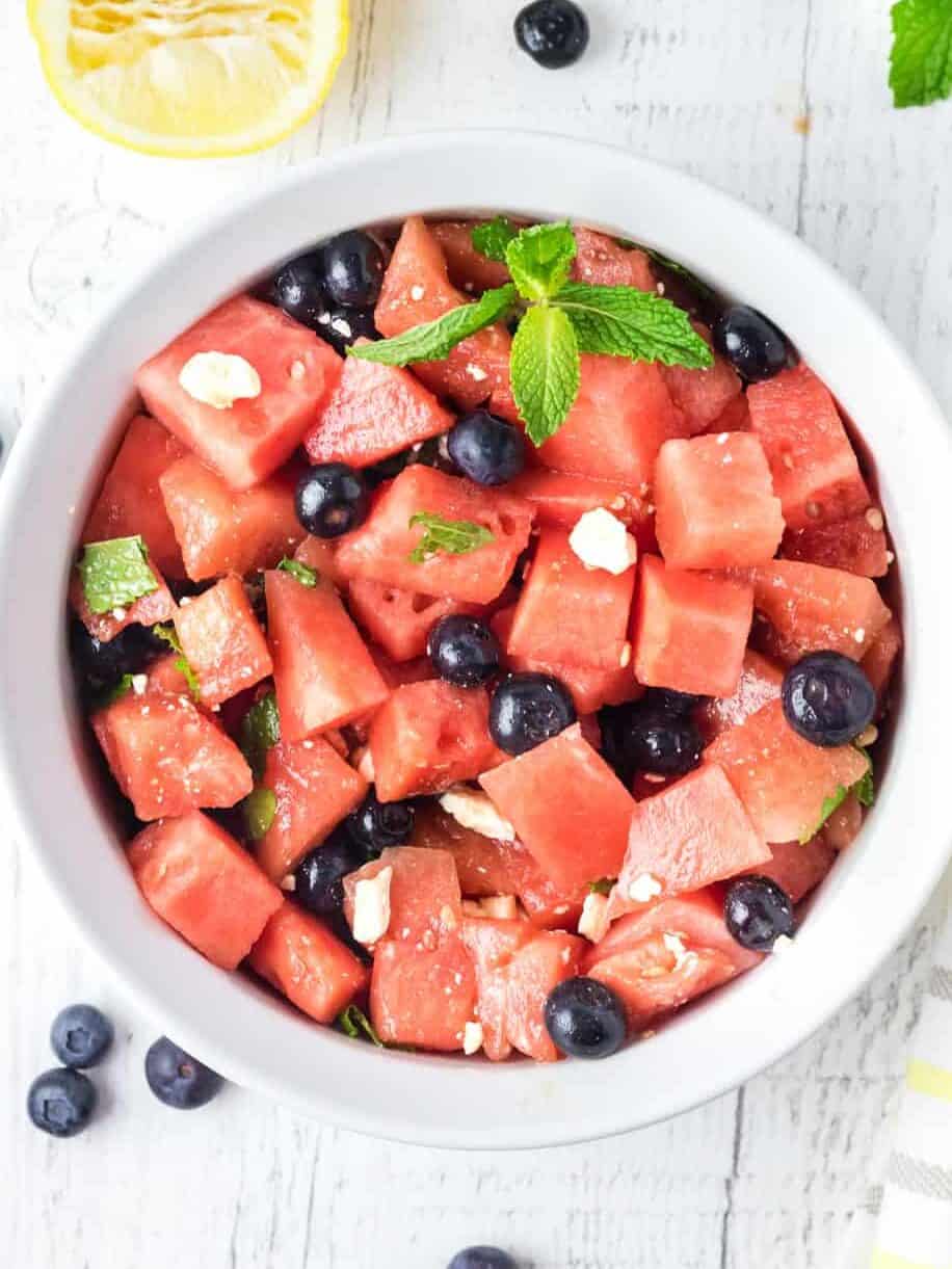 overhead view of watermelon salad in a white serving bowl.