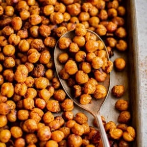 roasted chickpeas on a baking sheet with a spoon.