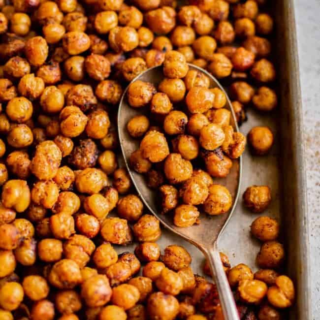 roasted chickpeas on a baking sheet with a spoon.