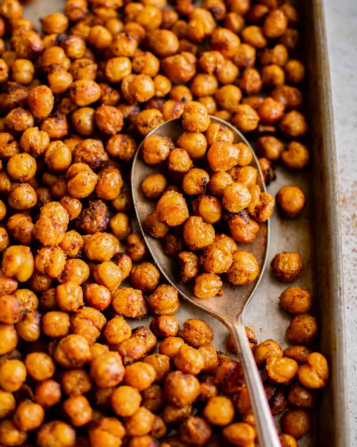 air fryer chickpeas on a baking sheet with a spoon.