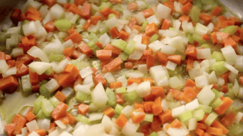 sautéed diced onions, carrots, and celery in a pan.