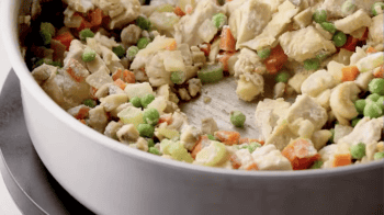 flour coated chicken pot pie filling in a pan.